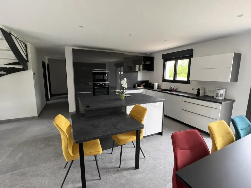 Cuisine bicolore anthracite et blanc avec îlot central à Raddon-et-Chapendu
