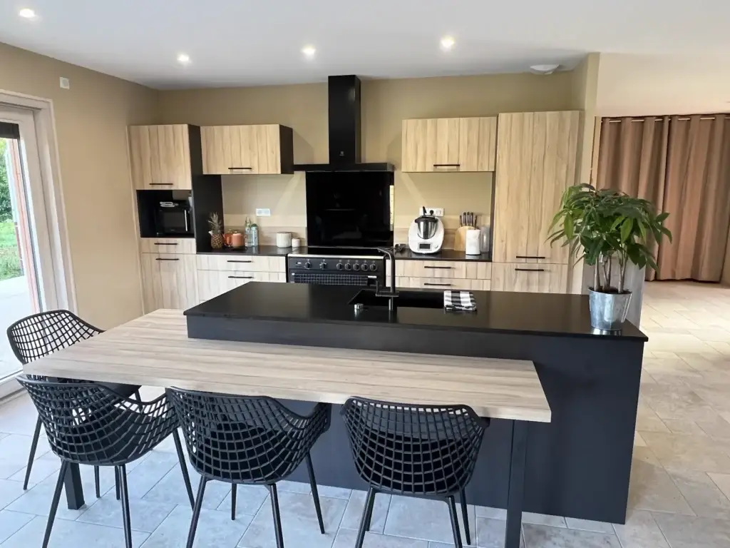 Cuisine en chêne clair avec granit noir et piano de cuisson à Saulx-les-Vesoul